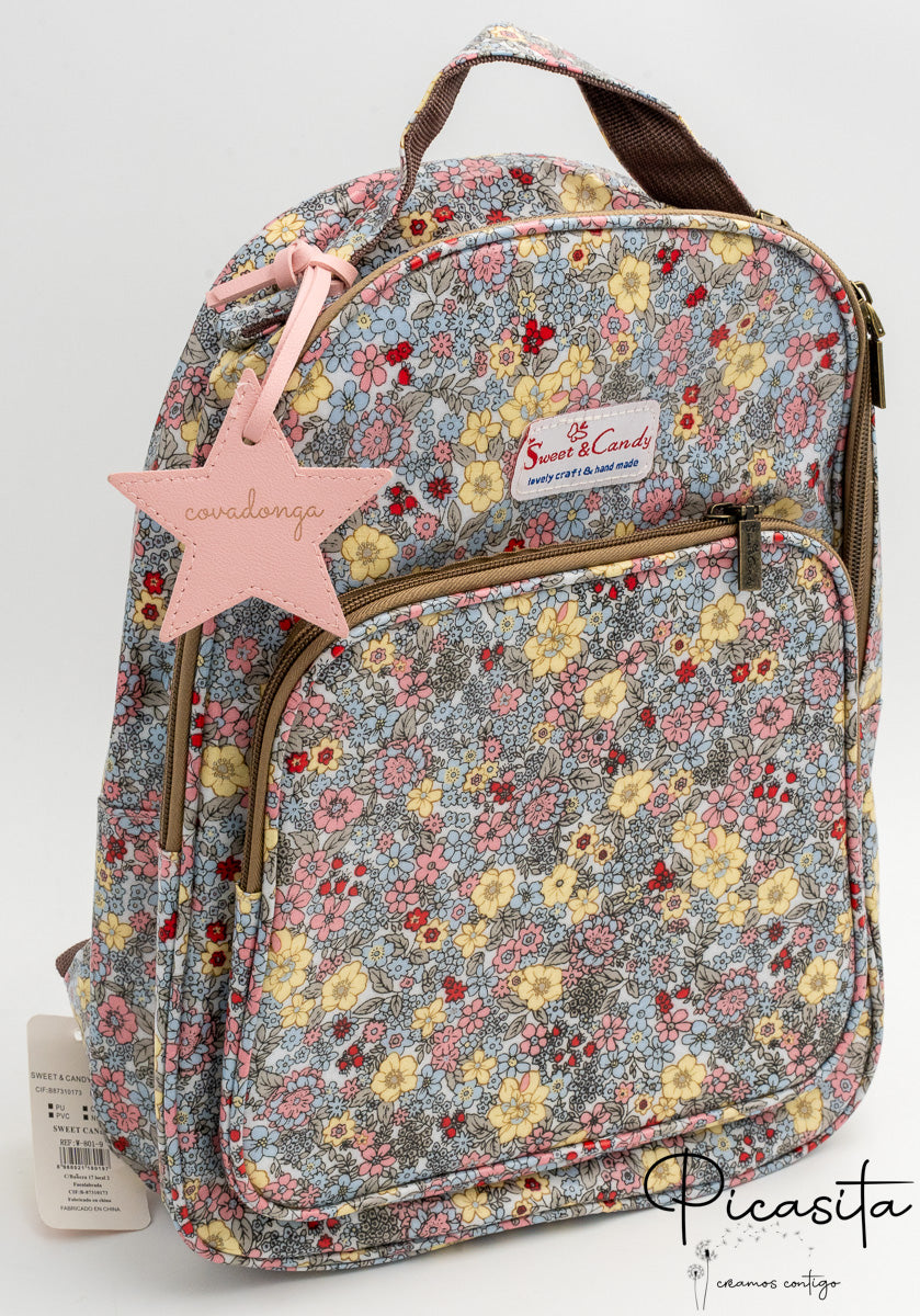 Mochila infantil azul con flores amarillas y charm rosa con nombre grabado.