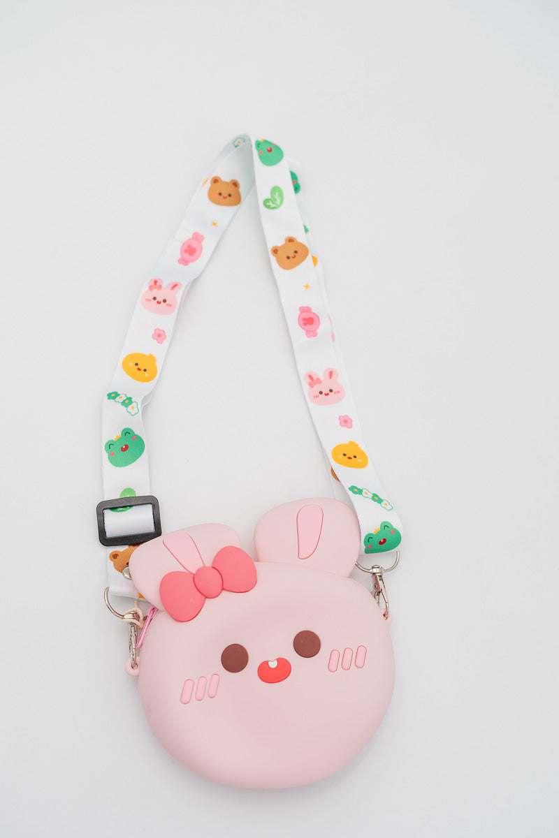 Bolso de silicona rosa claro con forma de conejo y correa blanca decorada.