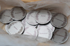 Detalle de monedas de boda grabadas con palabras como amor, familia y perdón.