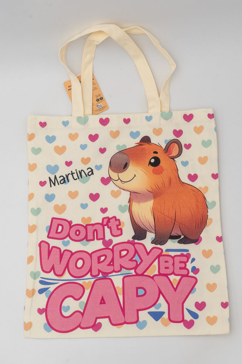 Bolsa de tela color crudo con dibujo de capibara, corazones de colores y nombre personalizado Martina.
