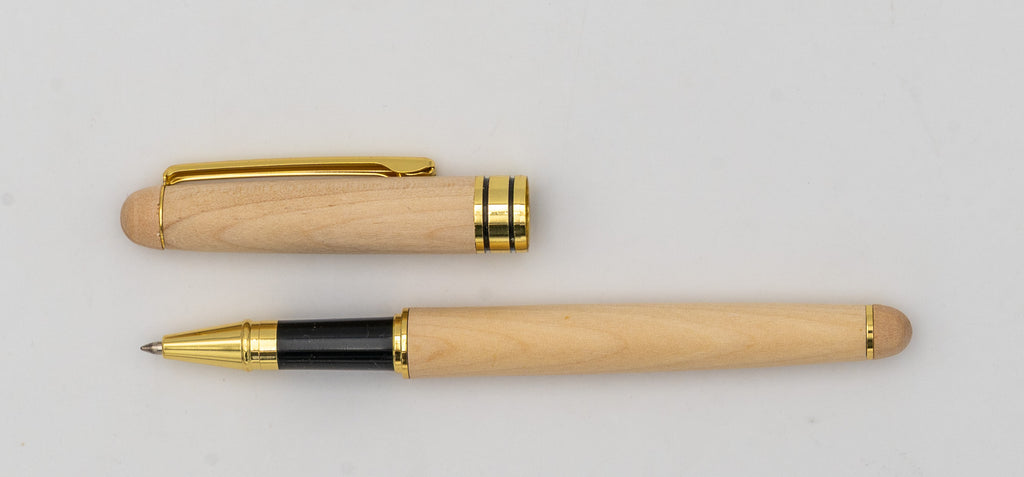 Bolígrafo de madera clara con la tapa retirada, clip dorado y zona de agarre negra.