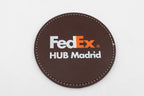 Posavasos redondo marrón con logotipo FedEx a color.