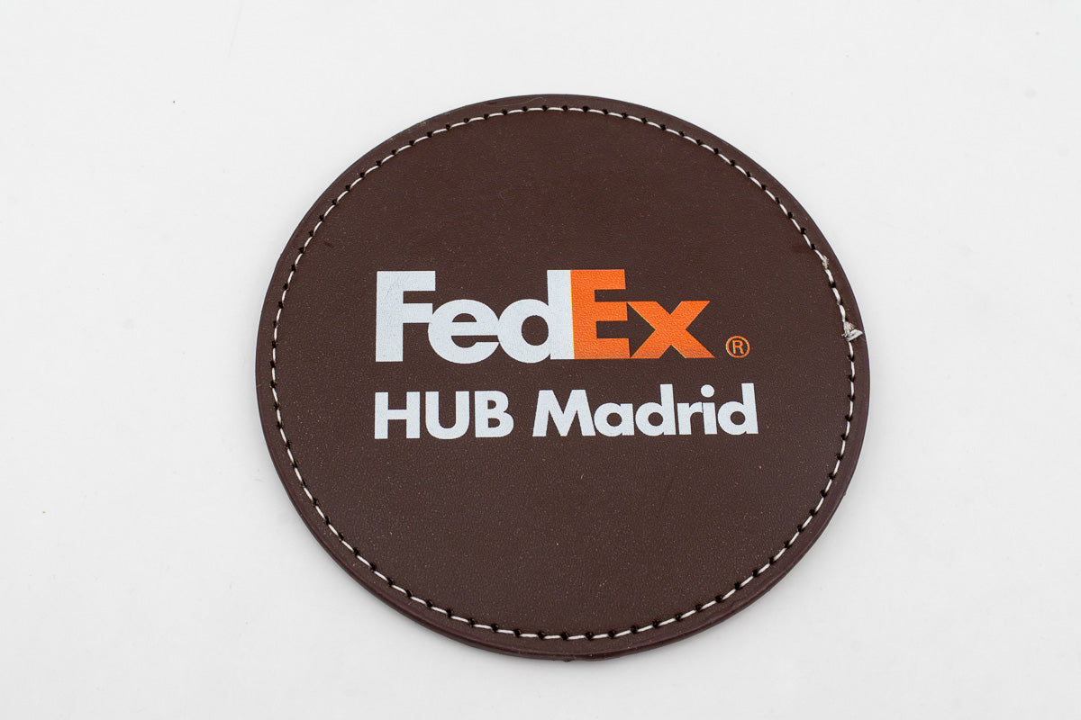 Posavasos redondo marrón con logotipo FedEx a color.