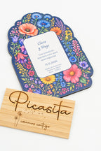 Invitación de boda de madera con flores silvestres de colores sobre fondo azul marino