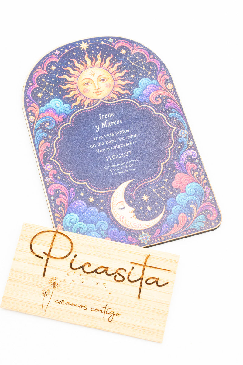 Invitación de boda de madera con forma de arco, un sol y una luna sobre fondo azul y morado