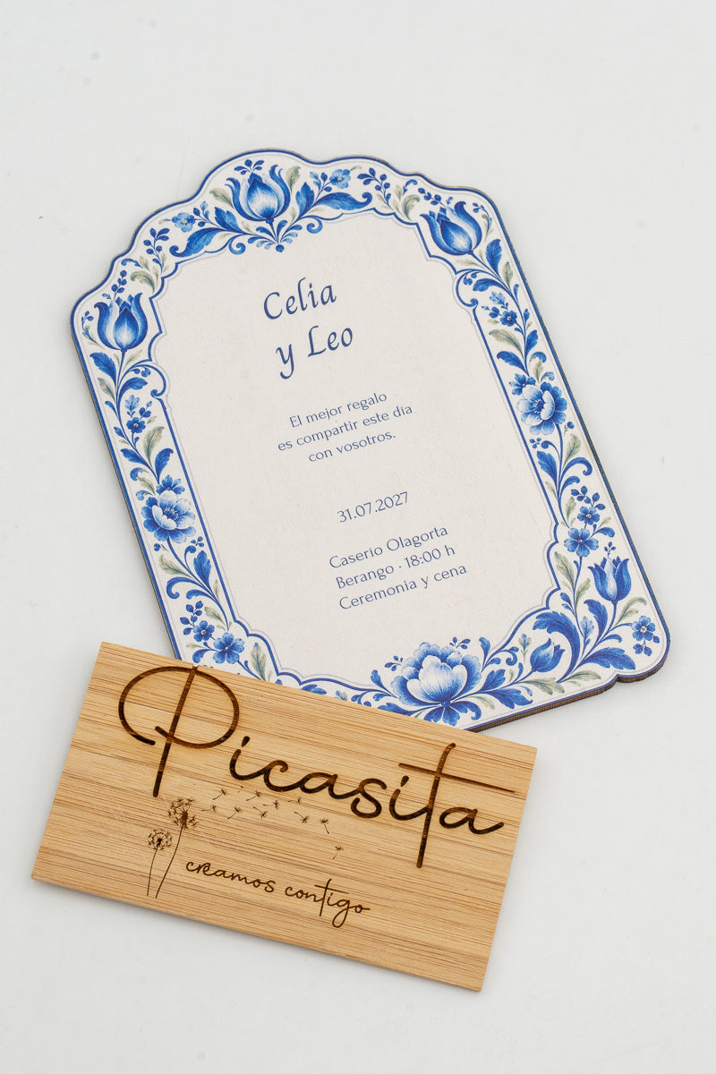 Invitación de boda de madera con marco de azulejos azules sobre fondo blanco