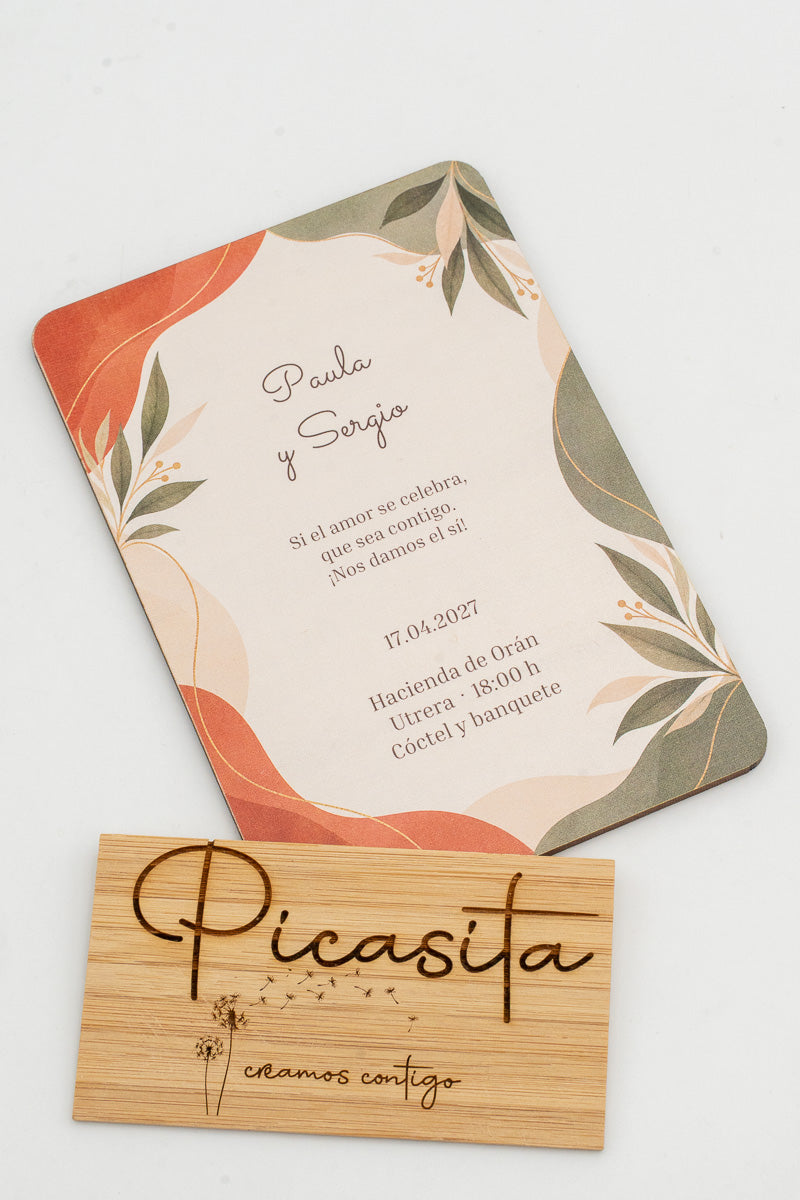 Invitación de boda de madera con hojas en tonos terracota y verde salvia