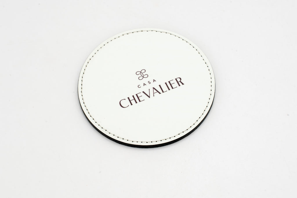 Posavasos redondo blanco con logotipo Chevalier gris.