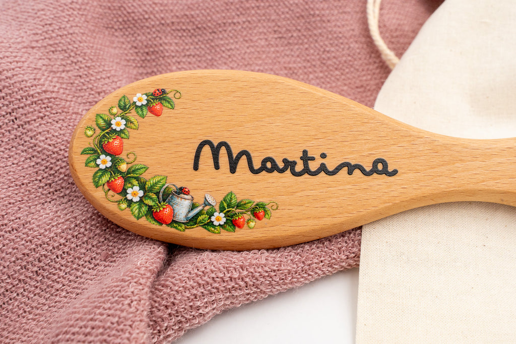 Detall d’un raspall amb el nom Martina i flors a color.
