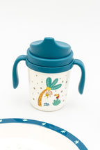 Vaso de aprendizaje azul con tapa y asas laterales para facilitar el agarre infantil.