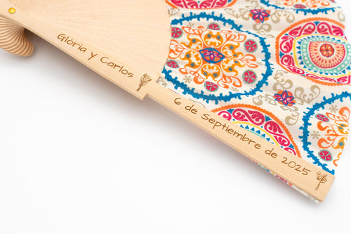 Abano con tela de mandalas de cores e os nomes Gloria e Carlos coa data gravados na madeira