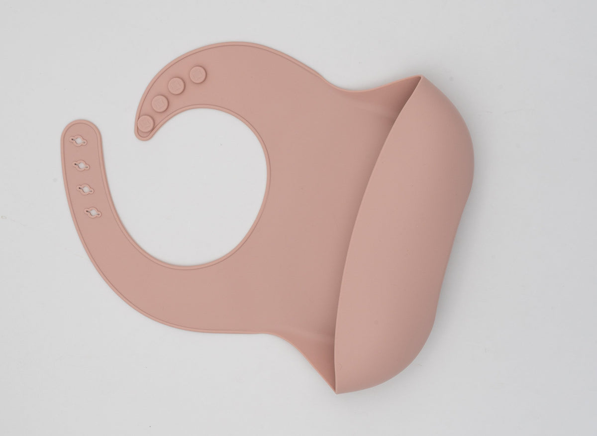 Babeiro de silicona con peto amplo en ton rosa empolvado