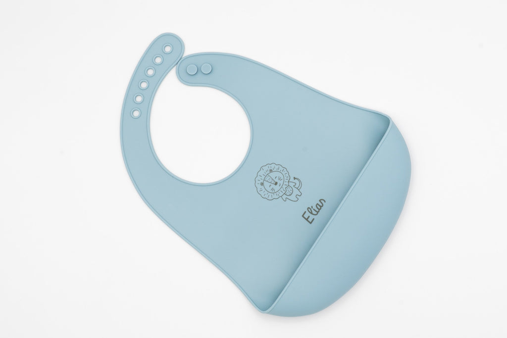 Pitet de silicona blau clar amb nom i dibuix de cara animal.