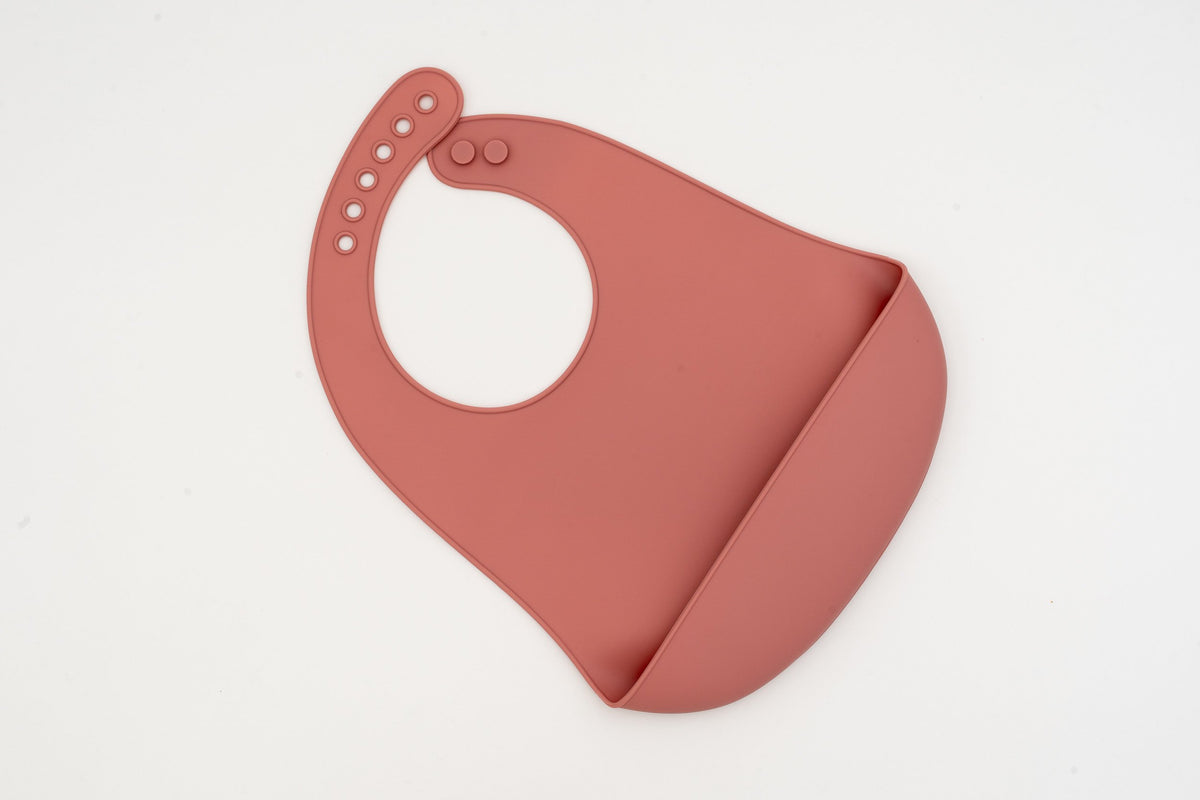 Babeiro de silicona rosa escuro con peto discreto