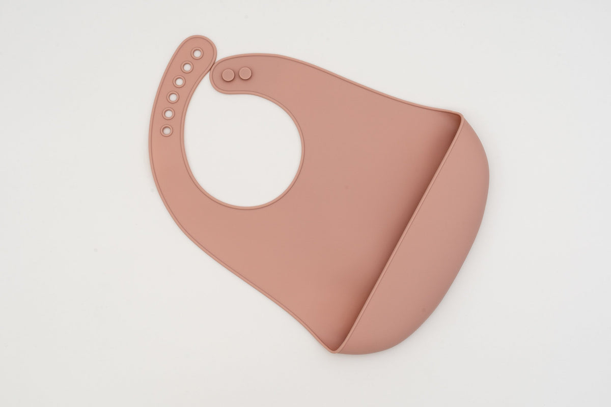 Babeiro de silicona rosa claro con peche axustable