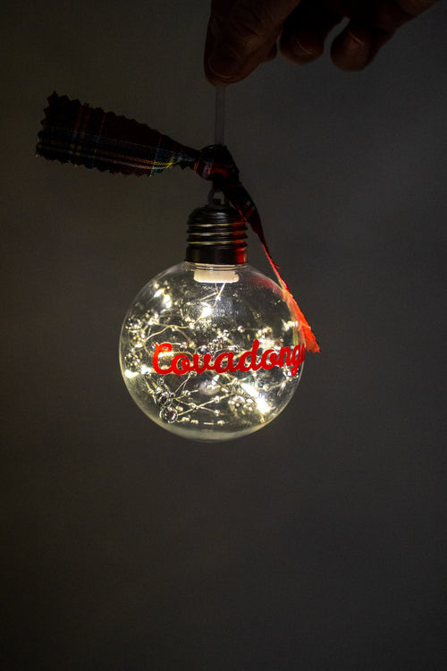 LED apaingarria piztuta, Covadonga izen gorriarekin eta zilar koloreko aleekin.