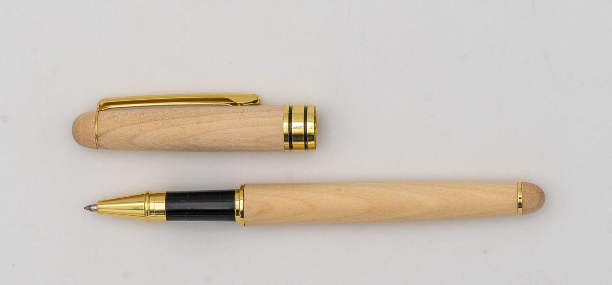 Bolígrafo de madeira clara coa tapa retirada, clip dourado e zona de agarre negra.