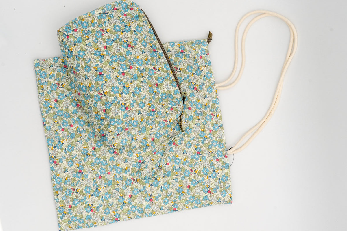 Bolsa e neceser con estampado floral verde sobre fondo branco de algodón resistente.