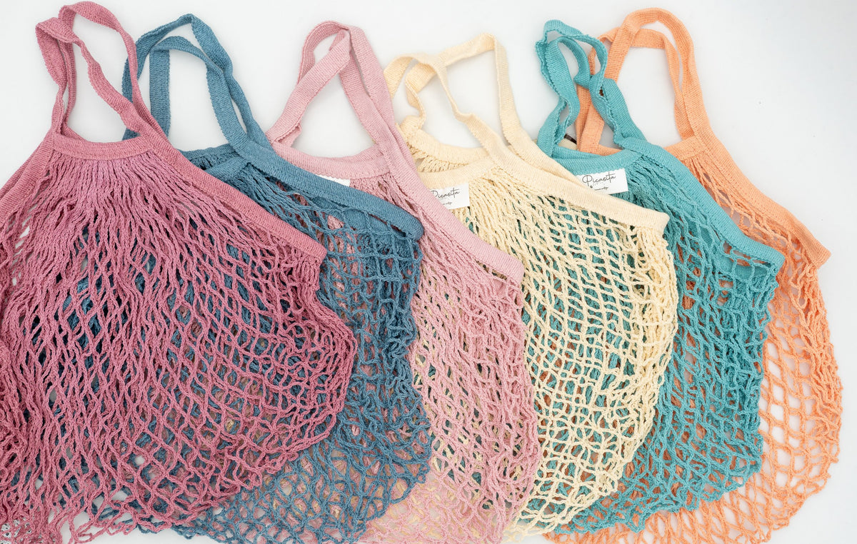 Conjunto de seis bolsas de malla de colores alineadas mostrando la variedad cromática disponible.