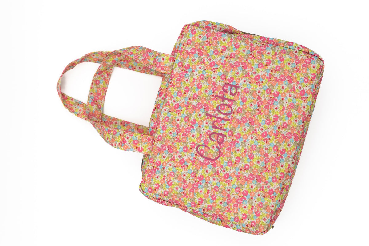 Bossa de canvi amb estampat de flors roses i el nom Carlota en vinil rosa