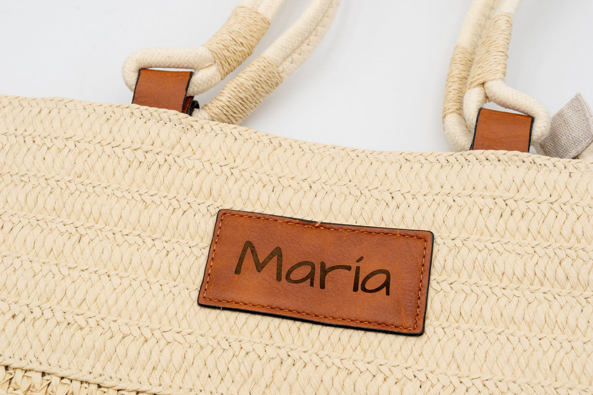 Parche de un bolso de rafia natural grabado con el nombre María