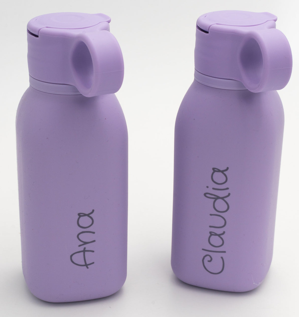 Dúas botellas lila personalizadas con nomes distintos