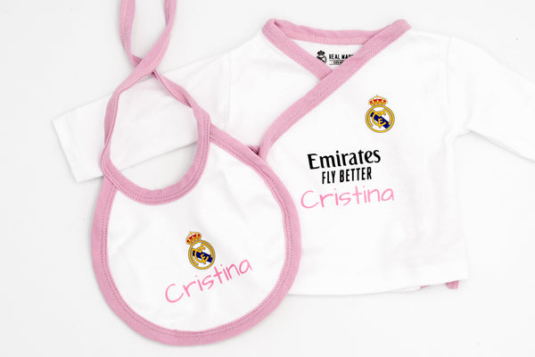 Camiseta blanca del Real Madrid con ribete rosa y el nombre Cristina en rosa, junto al babero