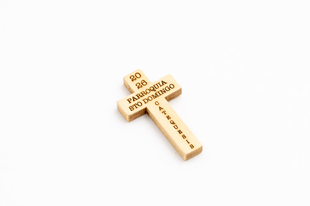 Cruz de madera clara con inscripción personalizada vista de cerca