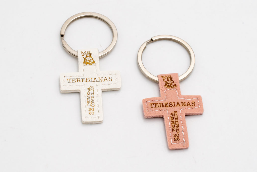 Dos llaveros de cruz blanca y rosa personalizados sobre fondo claro