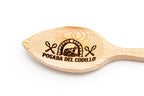 Primer plano de grabado láser detallado con motivos de cocina sobre madera clara pulida.