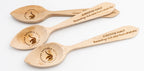 Tres cucharas de madera grabadas con mensajes de agradecimiento y logotipos de concursos culinarios.