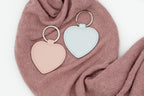 Chaveiros de corazón rosa e azul claro sen personalizar sobre tea rosa.