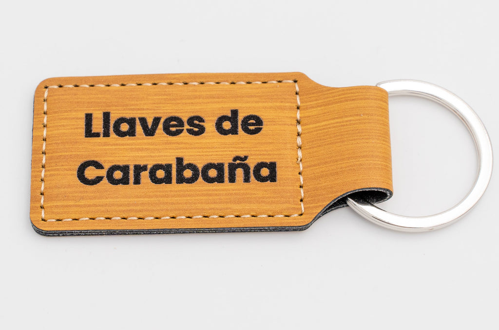 Clauer rectangular d'acabat fusta amb text fosc en dues línies.