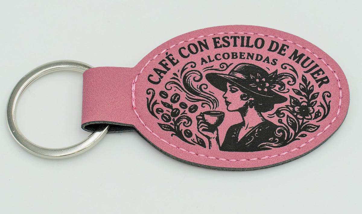 Clauer ovalat rosa amb il·lustració i text d'una cafeteria.