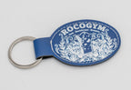 Clauer ovalat blau amb disseny ornamental clar i logotip.