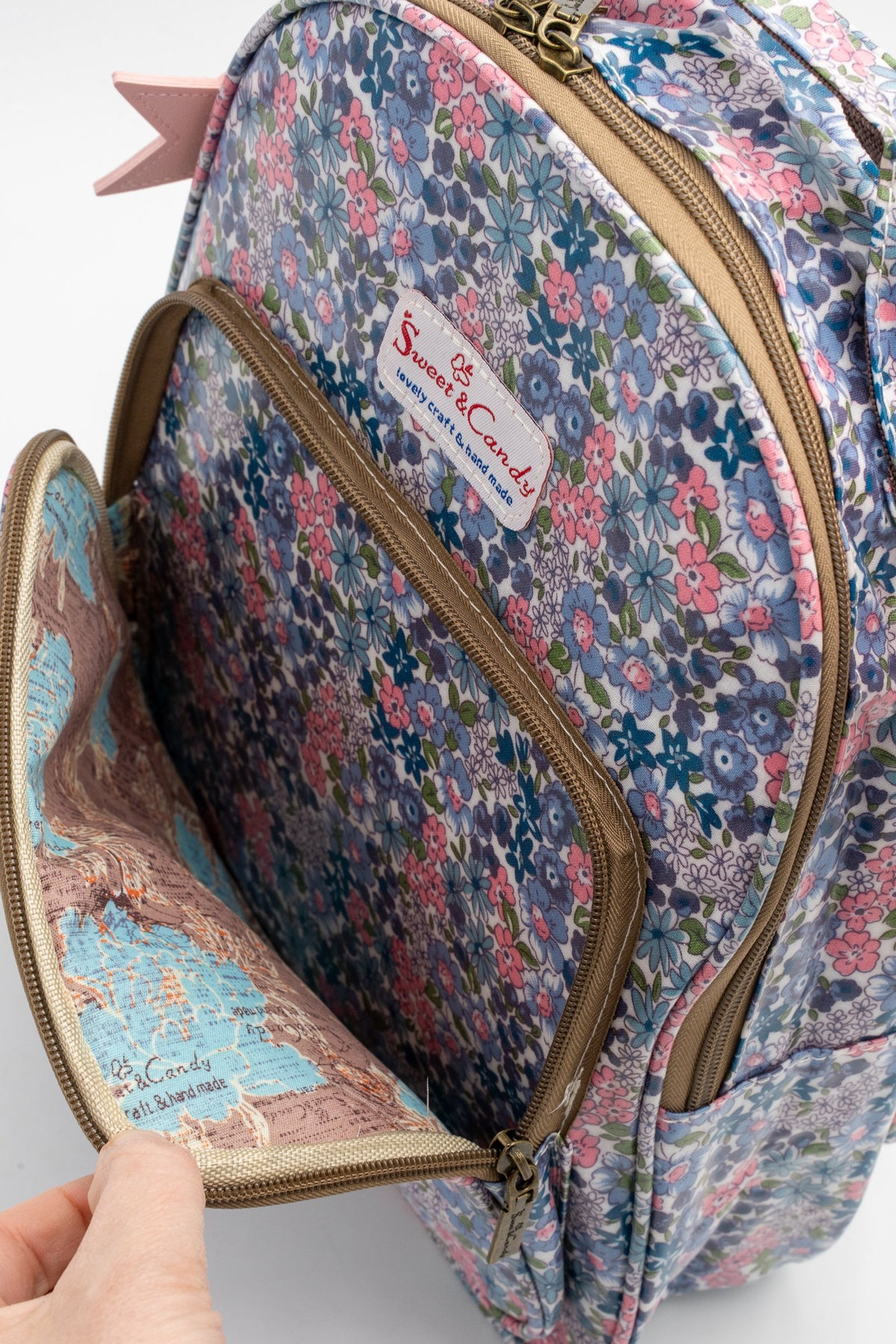 Detalle del bolsillo frontal abierto de la mochila y su forro interior estampado