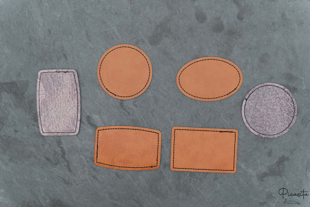 Conjunto de parches personalizados en diferentes formas geométricas sobre una superficie de piedra gris.