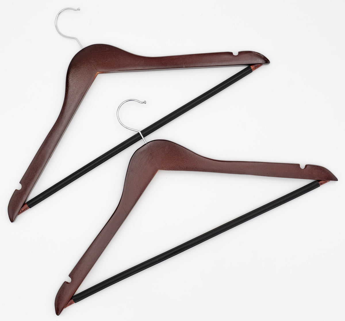 Dúas perchas de madeira escura con gancho metálico e barra negra para pantalóns.
