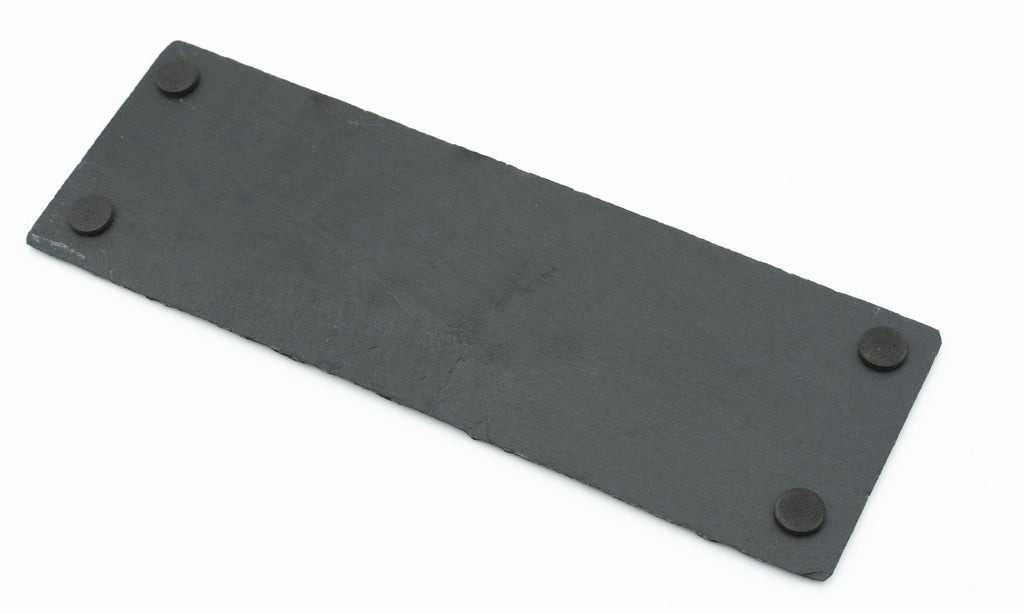 Parte trasera de plato de pizarra con cuatro protectores circulares antideslizantes en las esquinas.