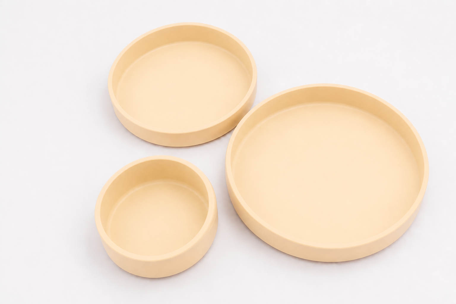 Juego de tres platos de silicona en color crema, mostrados en sus tres tamaños