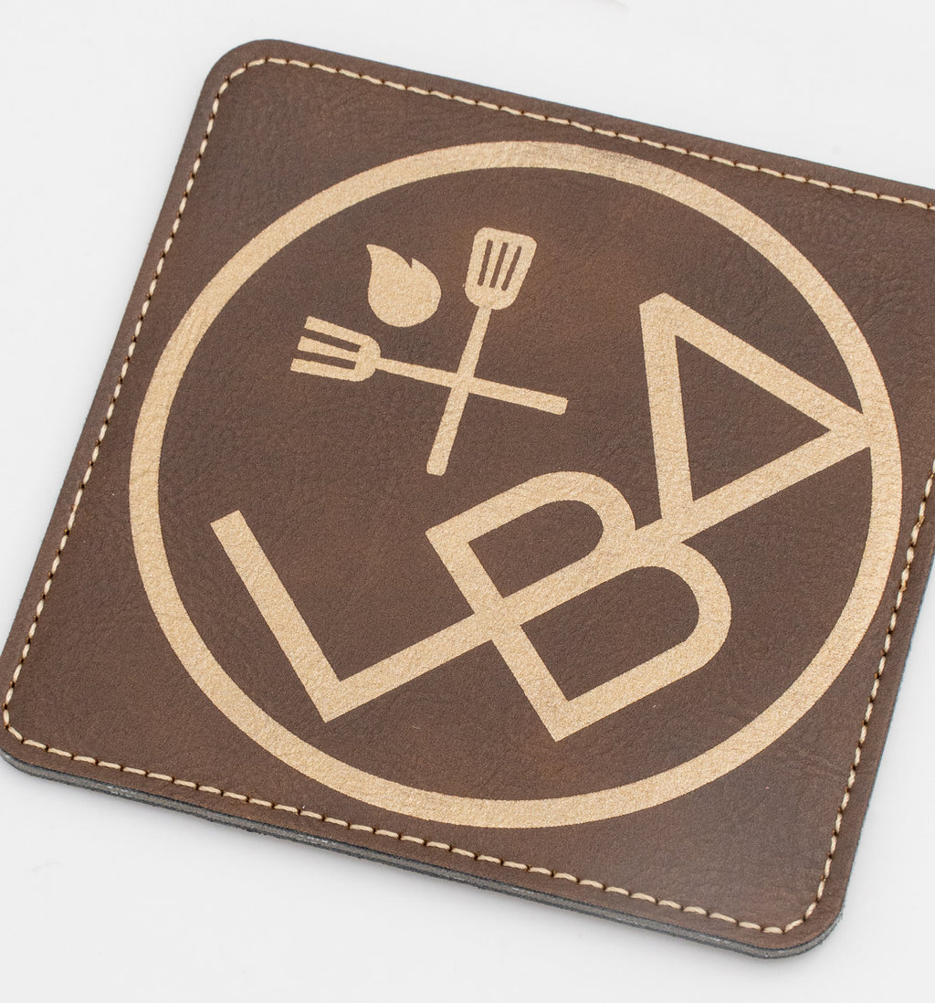Posavasos cadrado marrón con logotipo de restauración en ton dourado.