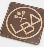 Posavasos cadrado marrón con logotipo de restauración en ton dourado.