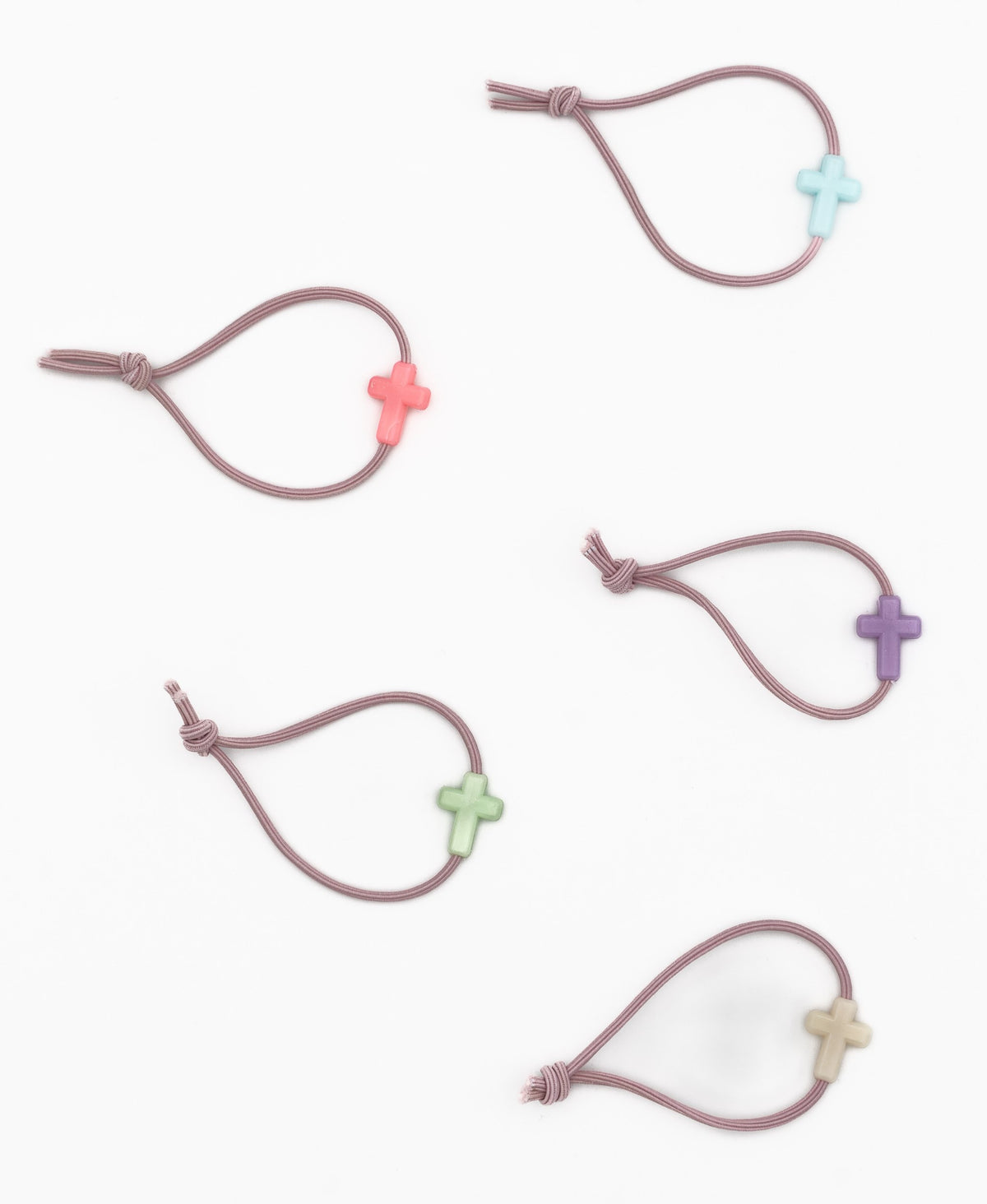 Cinco pulseiras elásticas de cor malva con motivos de cruces de silicona en tons variados.