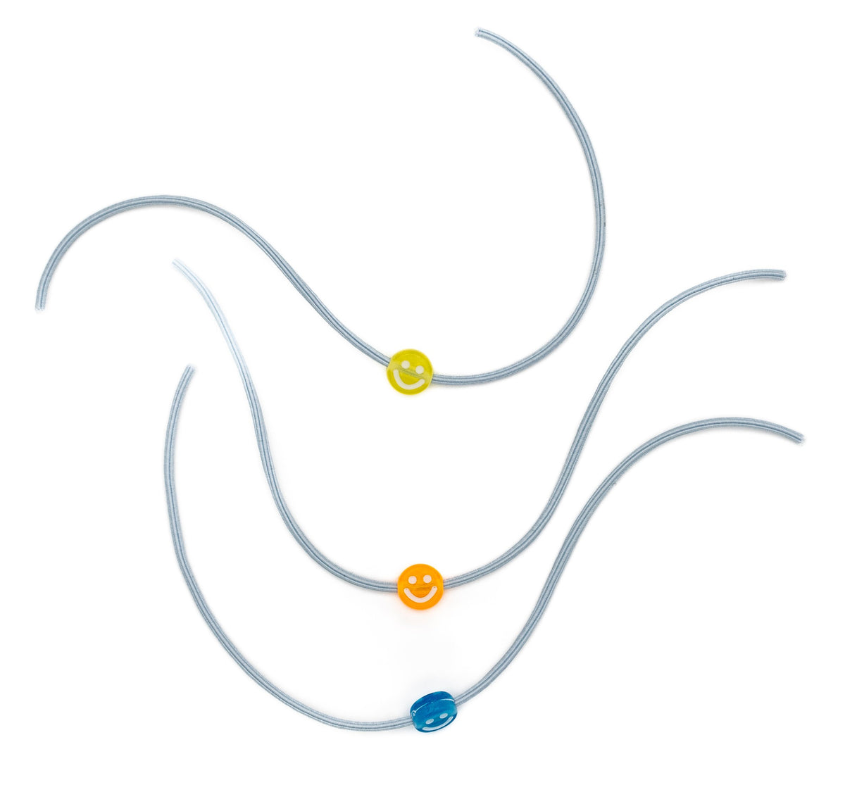 Tres pulseiras elásticas grises con contas de sorrisos nas cores amarela, laranxa e azul.