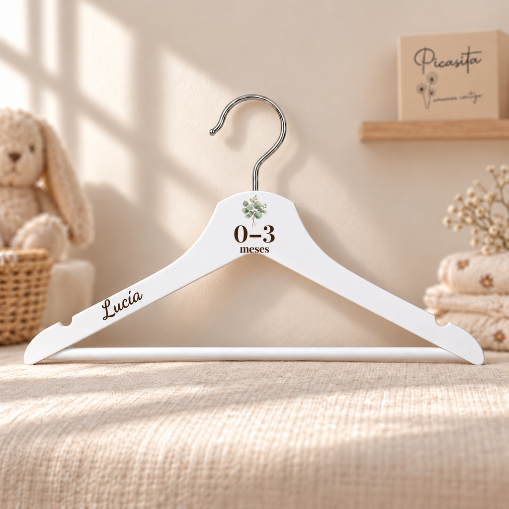 Separador de bebé en percha blanca personalizada, Botánica suave, 0–3 meses y nombre Lucía. Composición actualizada con edad y nombre ampliados. Simulación del acabado.