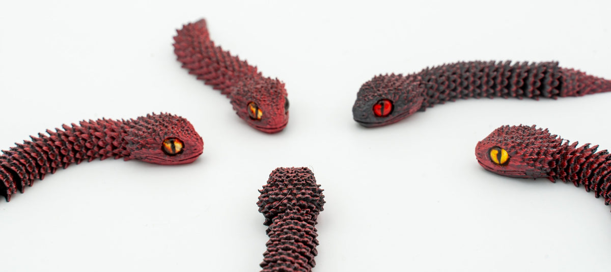 Serpes 3D articuladas en tons vermello escuro en detalle