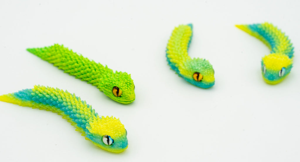 Serpes 3D articuladas en degradado verde e amarelo vistas de preto