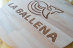Vista oblicua del tablero redondo con el logotipo La Ballena grabado.