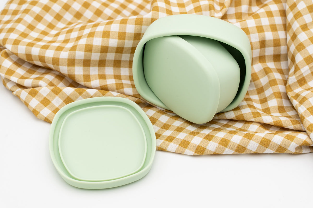 Tupper verde pequeño guardado dentro del grande con las tapas separadas