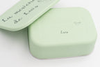 Detalle de tupper XL verde claro personalizado con frase y nombre